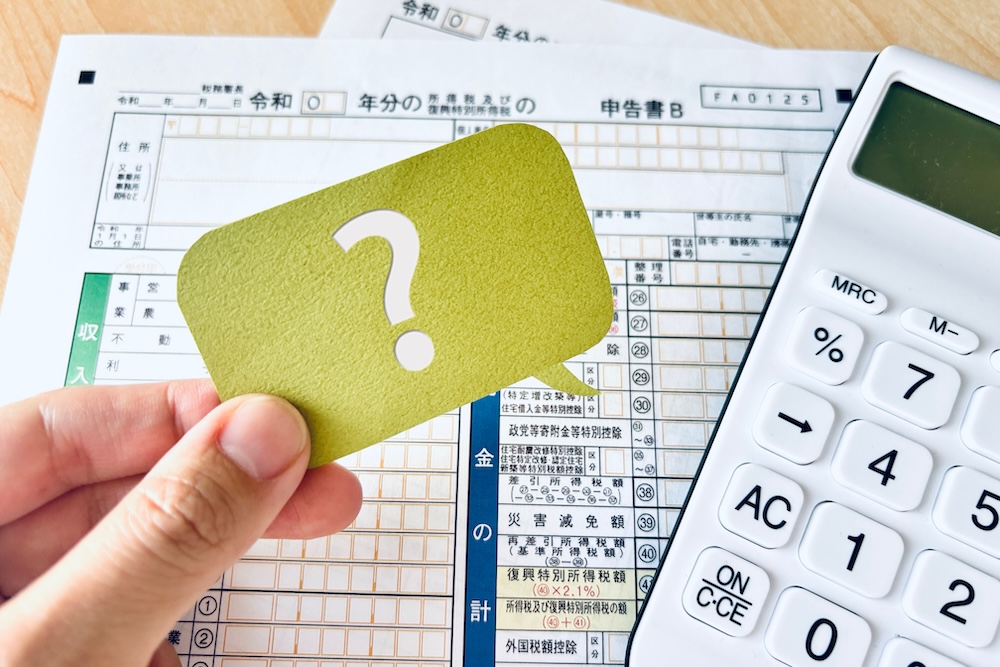 ハテナが書いてある紙を持つ手