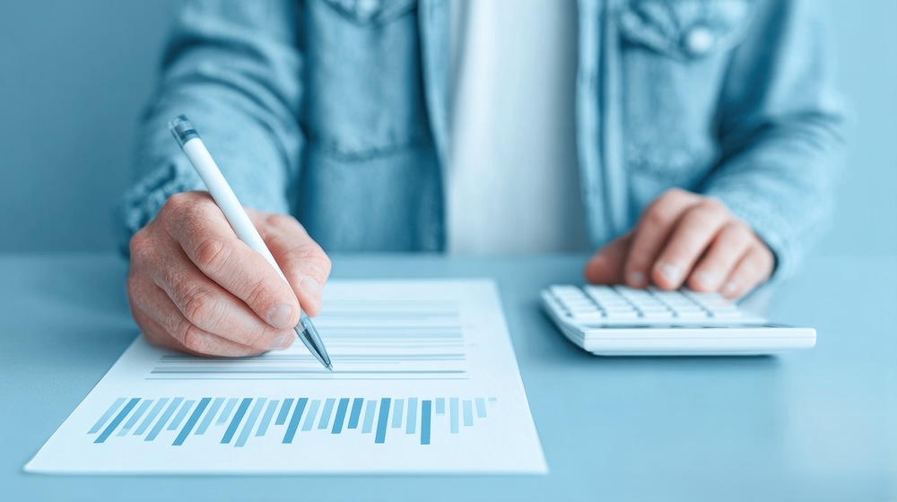 用紙とペンを持つ手元